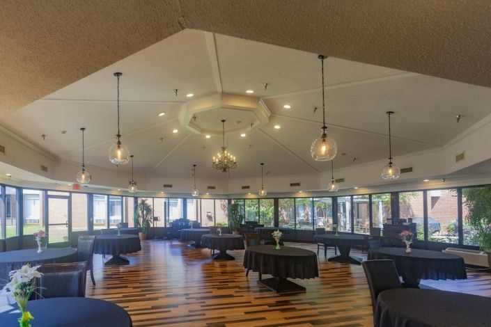 A spacious dining area with modern pendant lighting and wooden flooring.