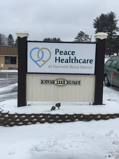 A sign for Peace Healthcare in a snowy outdoor setting.
