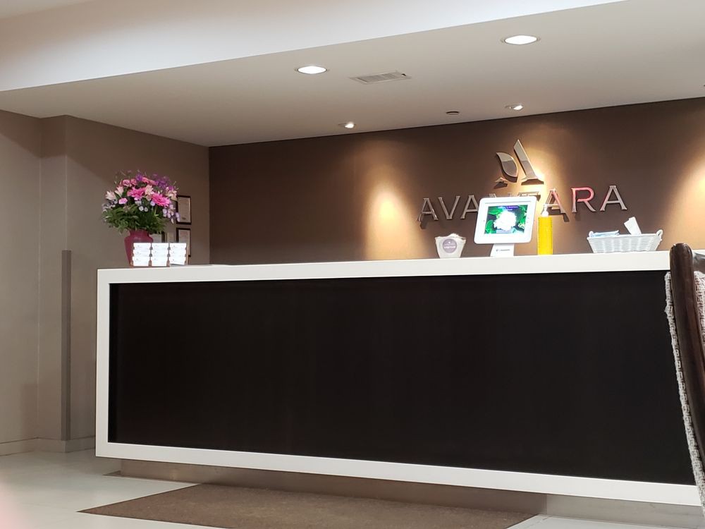 Modern office reception area with a sleek desk and decorative flowers.
