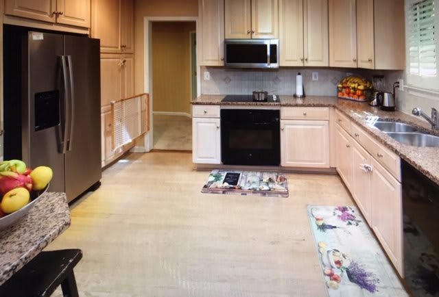 A modern kitchen with stainless steel appliances and wooden cabinetry.