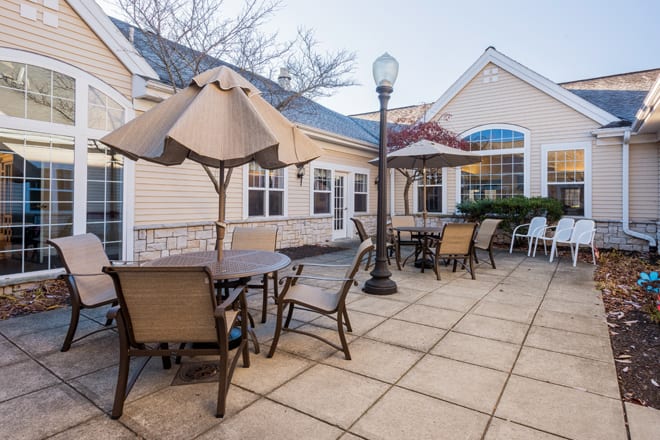 Outdoor patio area with tables and chairs under umbrellas.