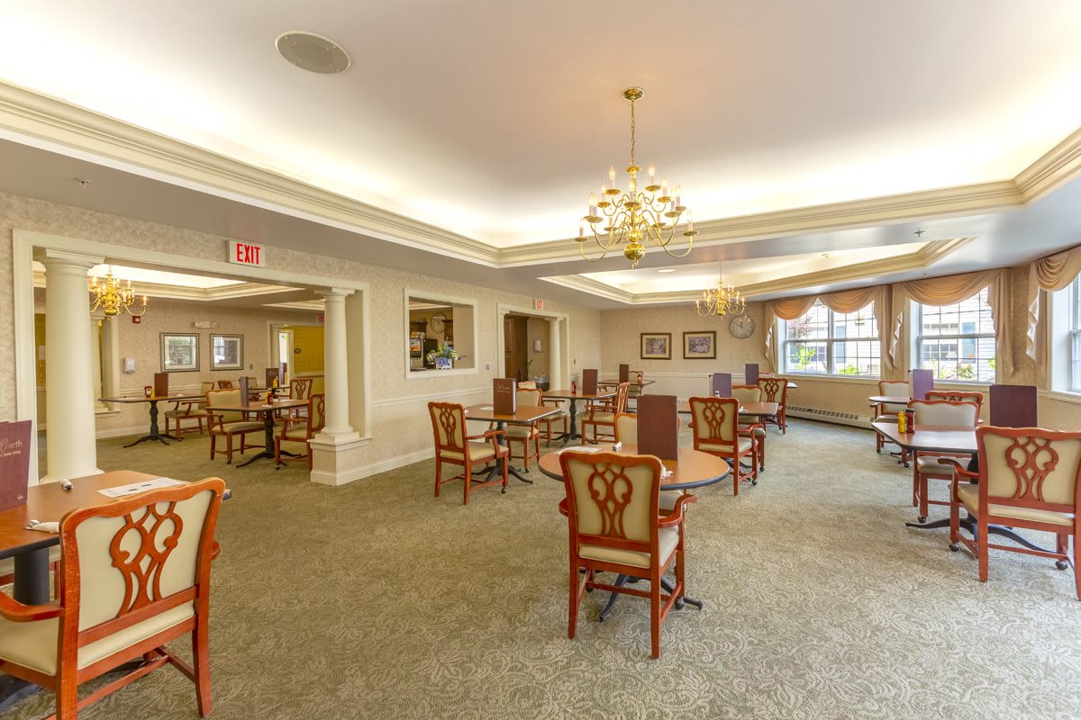 A spacious dining room featuring elegant furniture and a chandelier.