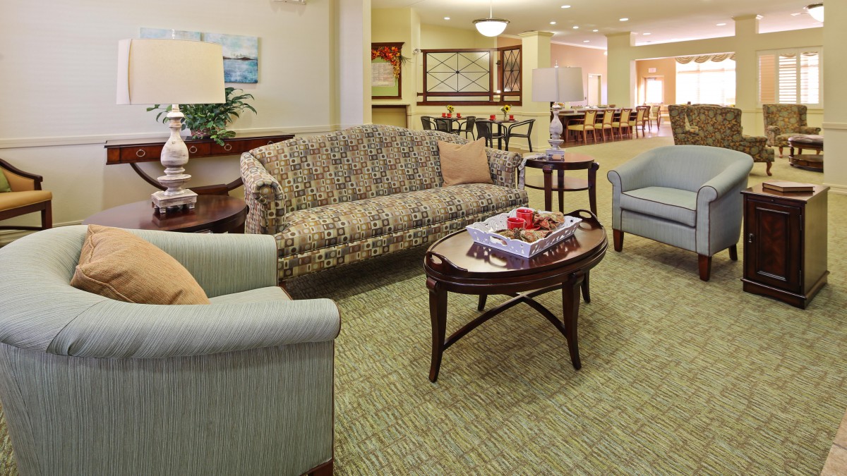 A cozy living room setup with a sofa, chairs, and a coffee table in a well-lit interior.