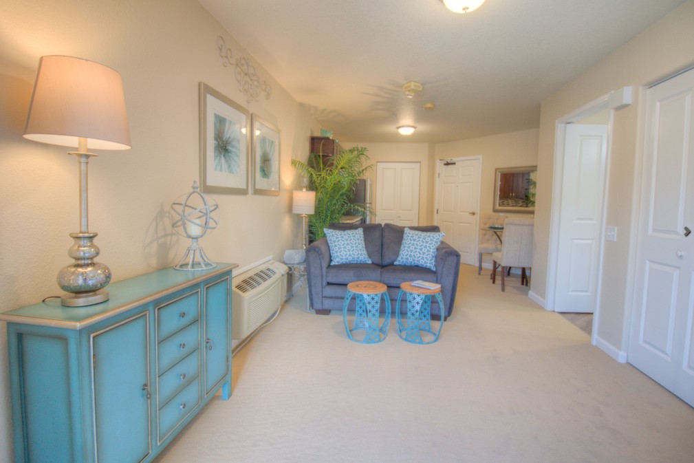 A cozy living room with a blue sofa, complemented by light walls and decorative elements.