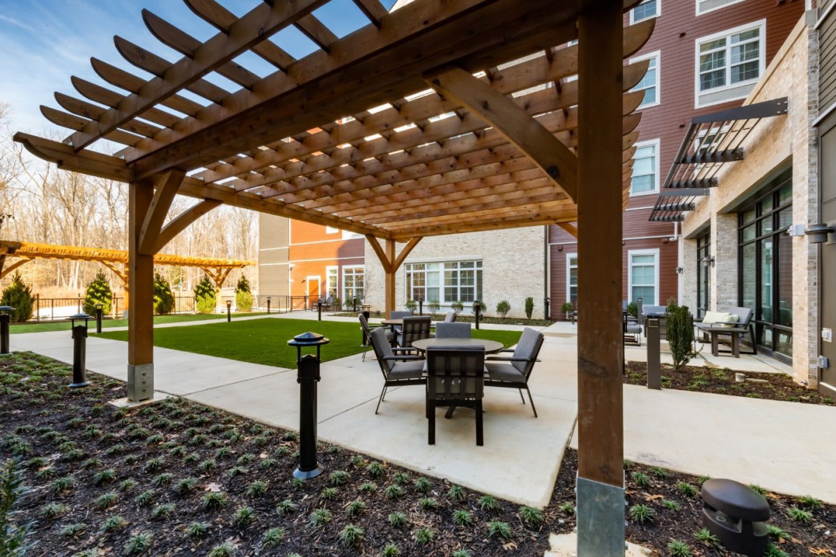 A modern courtyard with a pergola and outdoor seating area.