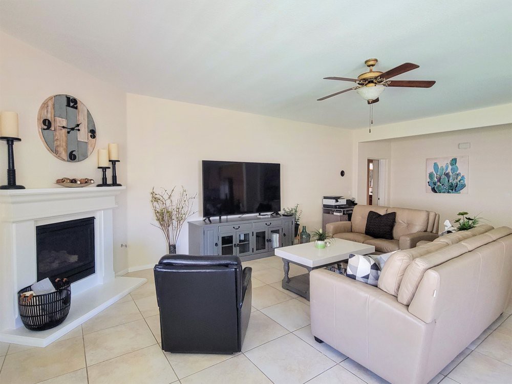 A cozy living room featuring a large television, stylish sofas, and a modern fireplace.