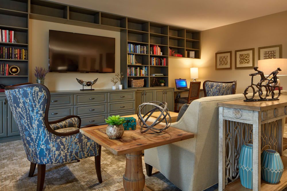 A cozy living room with a large bookshelf, comfortable seating, and elegant decor.