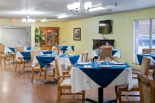 A cozy dining area with neatly arranged tables, featuring blue and white table settings.