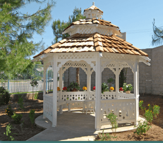A charming white gazebo with a wooden roof in a garden setting.
