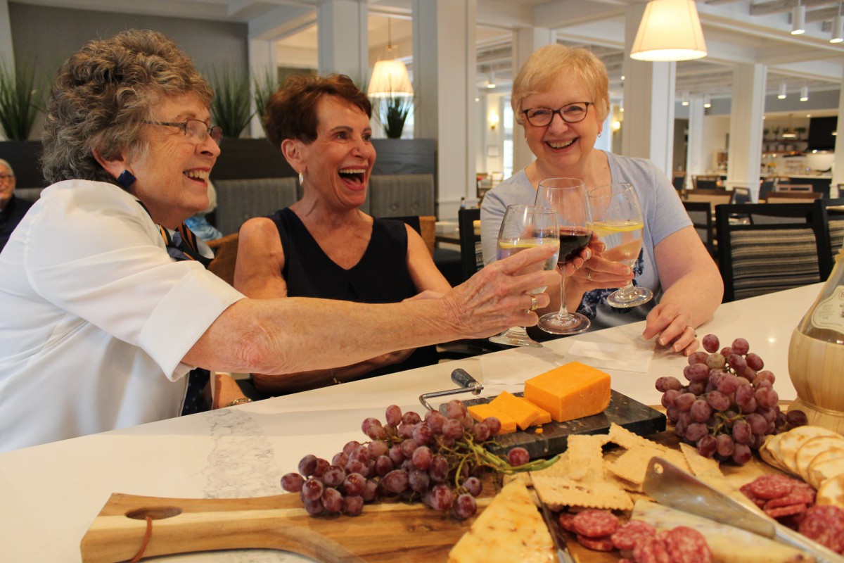 A group of friends enjoying wine and cheese together.