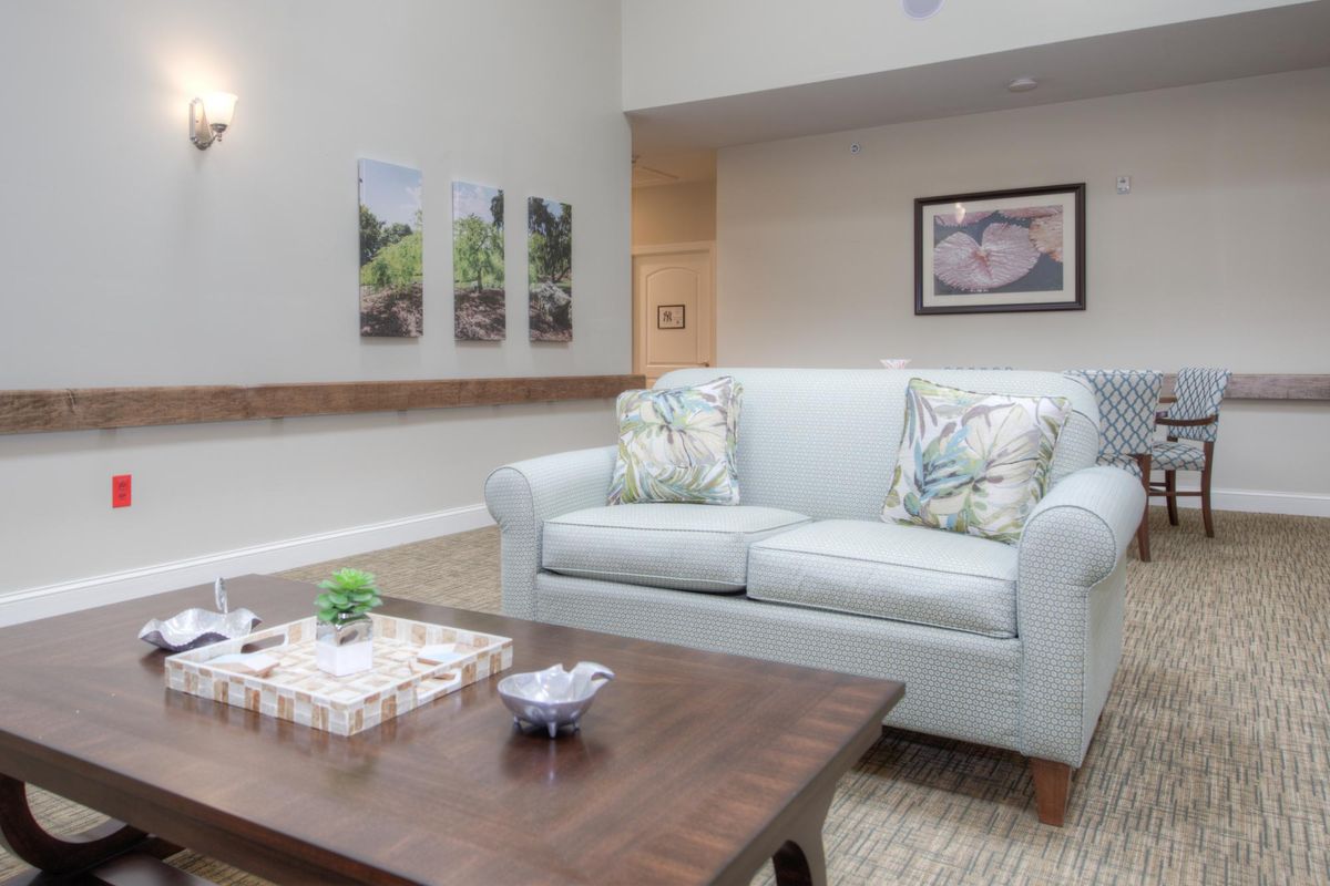 A cozy living room with a comfortable sofa, a wooden coffee table, and decorative artwork on the walls.