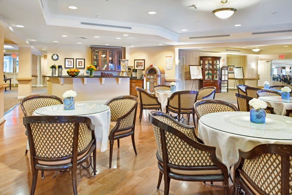 An elegant dining area with neatly arranged tables and chairs, featuring warm lighting and tasteful decor.