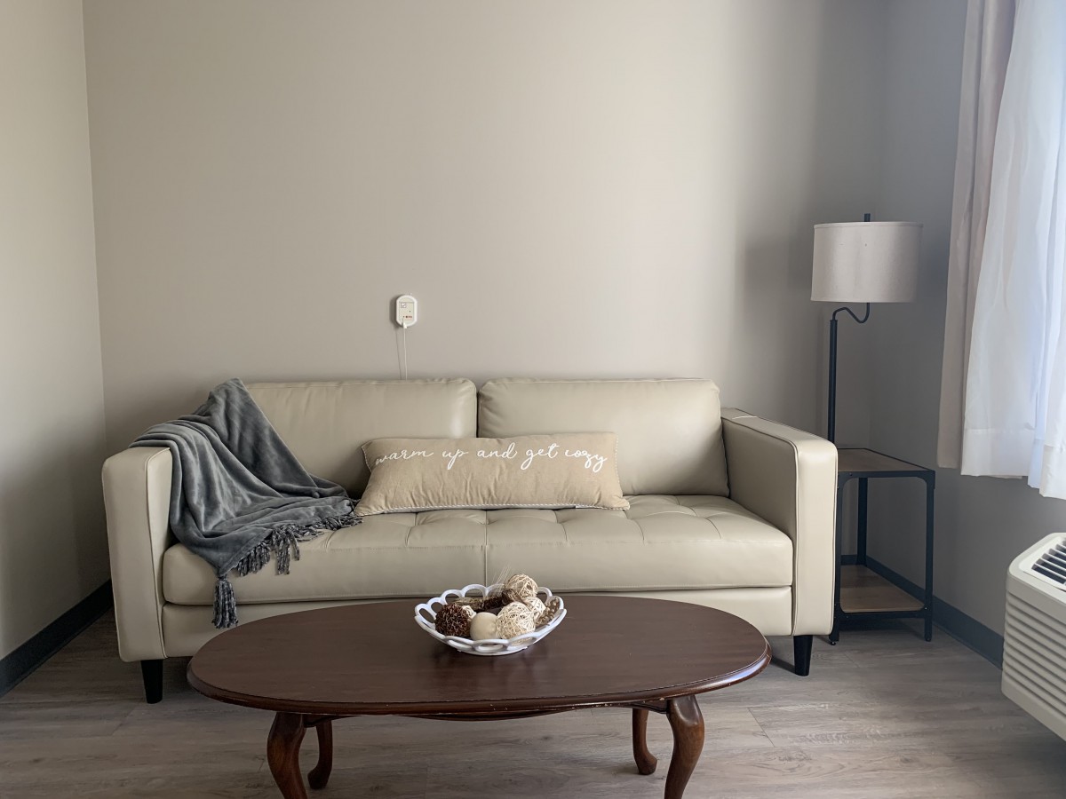 A cozy living room with a sofa, coffee table, and a standing lamp.