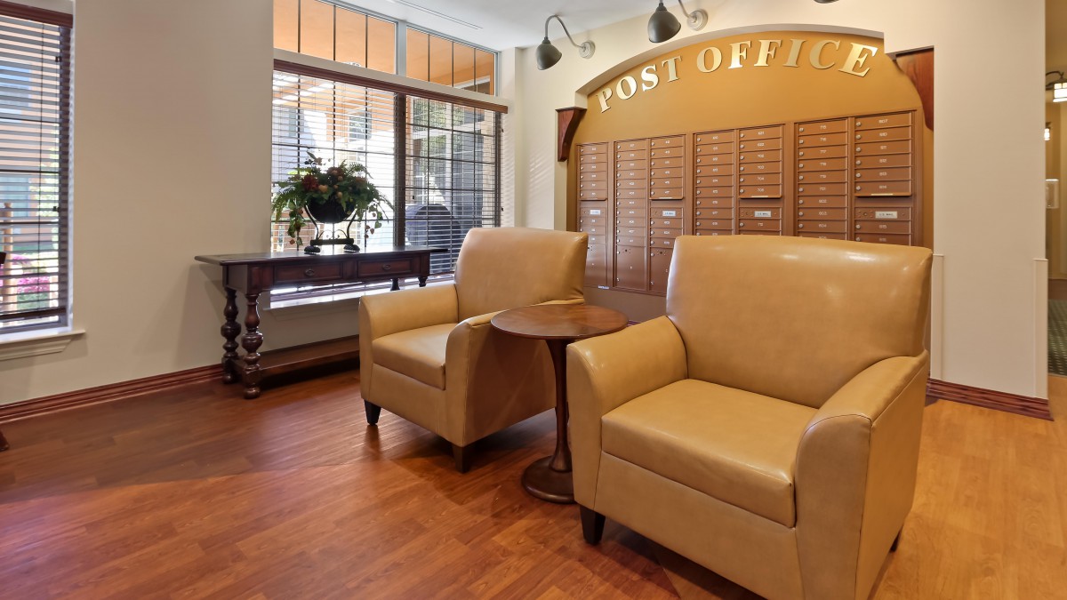 A cozy waiting area with comfortable chairs and a small table in a post office lobby.