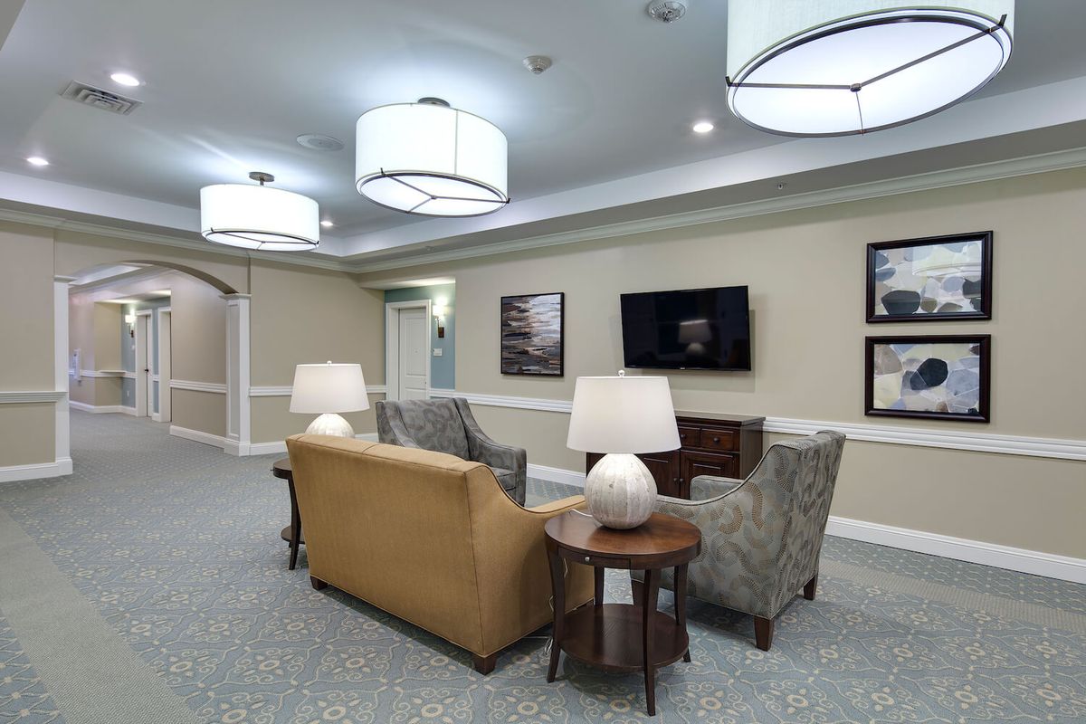 A modern living room with comfortable seating, table lamps, and a wall-mounted television.