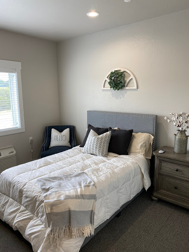 A cozy and modern bedroom featuring a neatly made bed, stylish cushions, and minimalistic decor.