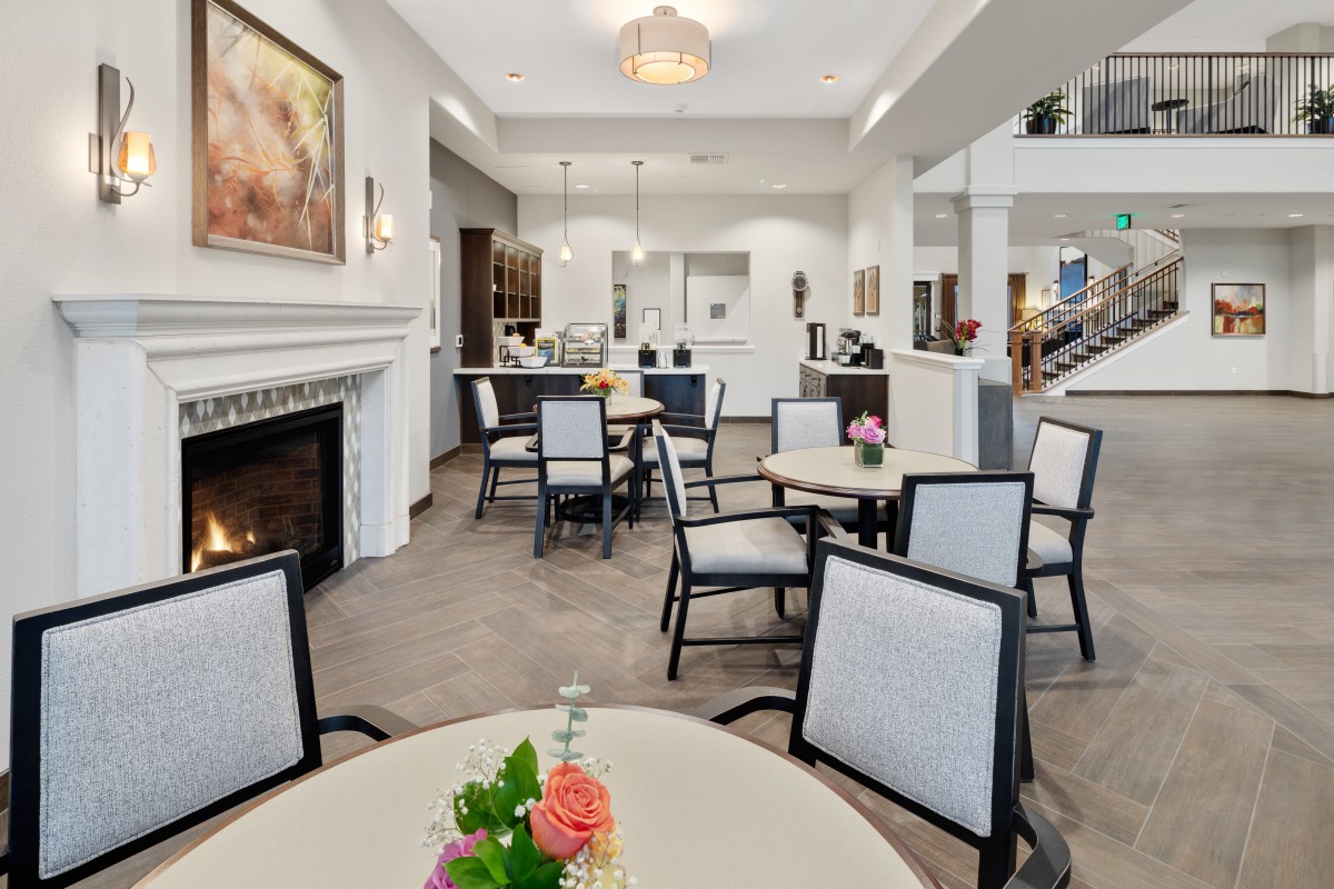 A modern dining area with a fireplace and elegantly arranged tables and chairs.