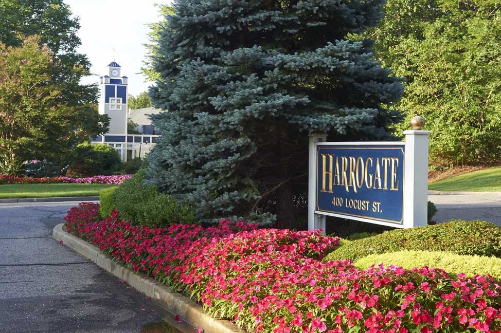A well-maintained garden with a sign and building in the background.