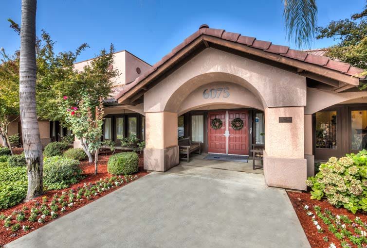 A welcoming entrance to a residential building with landscaped surroundings.