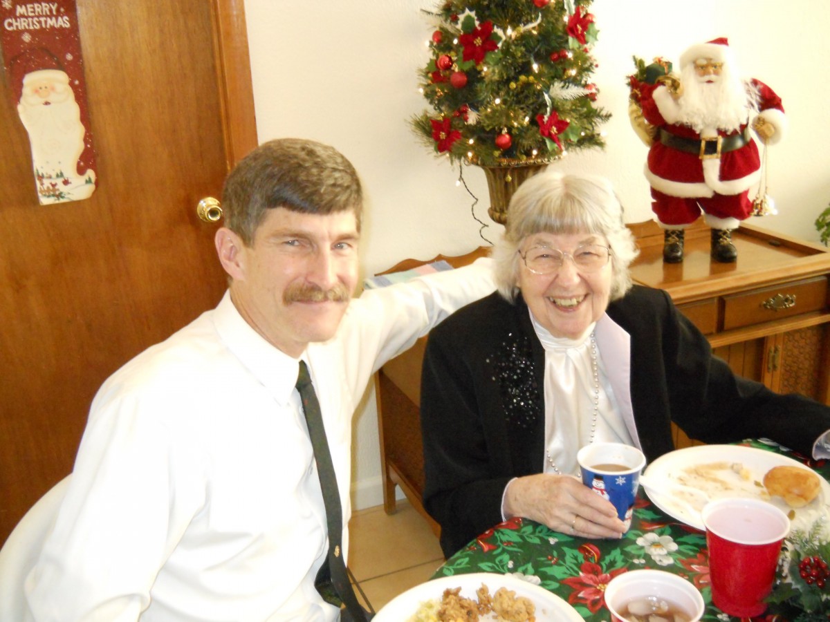 A cheerful family gathering during the Christmas season, with a decorative tree and Santa figure in the background.
