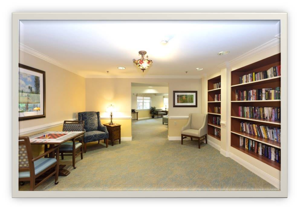 A cozy interior library space with bookshelves, comfortable seating, and warm lighting.