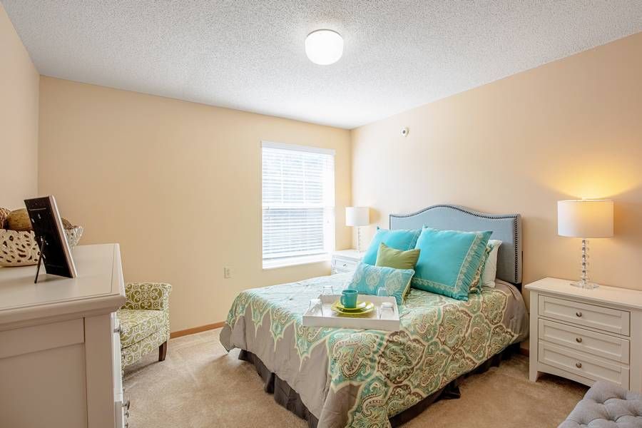 A cozy bedroom with pastel decor and natural lighting.