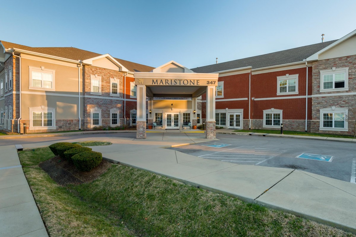 A large building with an entrance canopy under a clear sky.