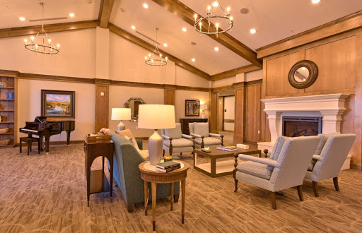 A cozy living room featuring traditional furniture, warm lighting, and a welcoming fireplace.