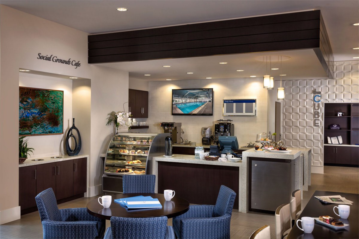 A modern coffee shop interior featuring a beverage counter and comfortable seating.