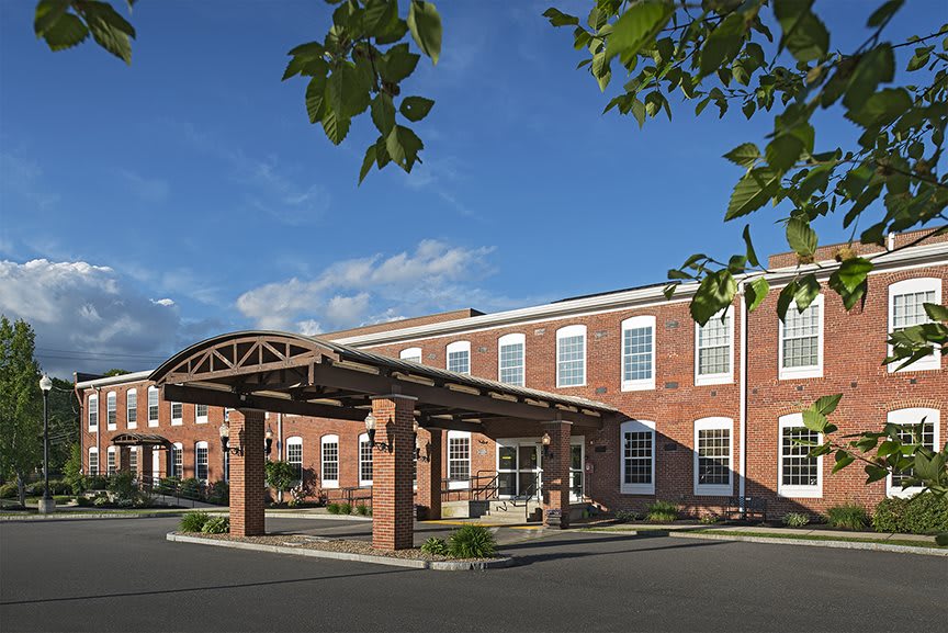A brick building with a covered entrance, set against a clear blue sky.