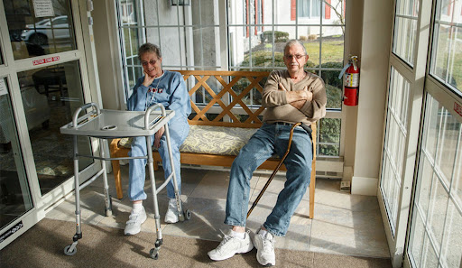 Two seniors relaxing together in a sunlit indoor setting.