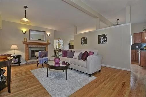 A cozy living room with a modern design, featuring a comfortable sofa, coffee table, and fireplace.