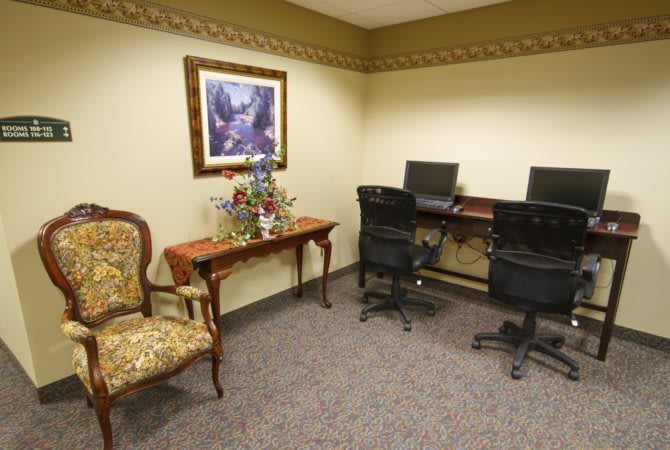 A small office space with computers, chairs, and decorative furniture.