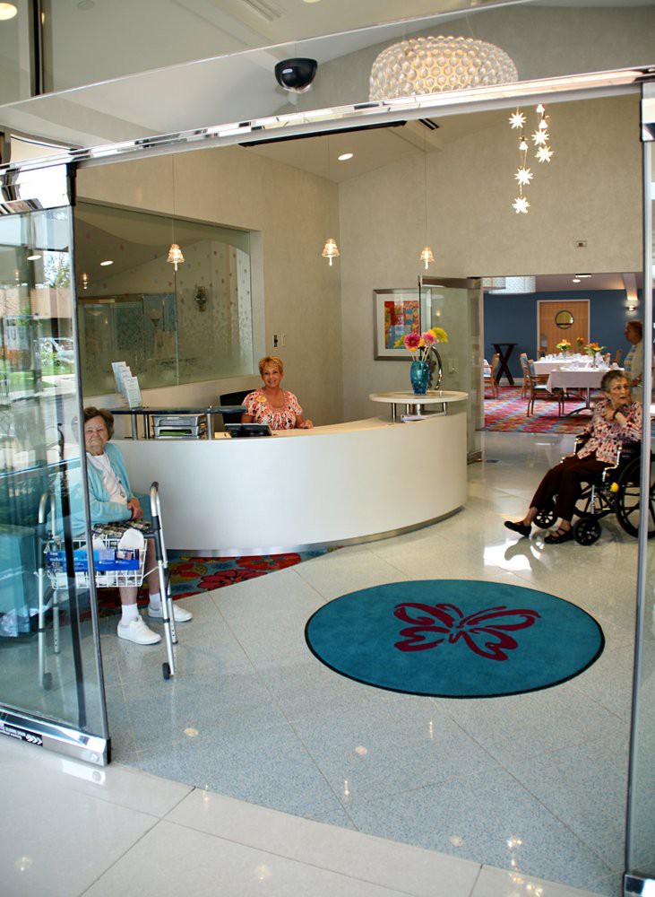 A hospital reception area with staff and patients in wheelchairs.