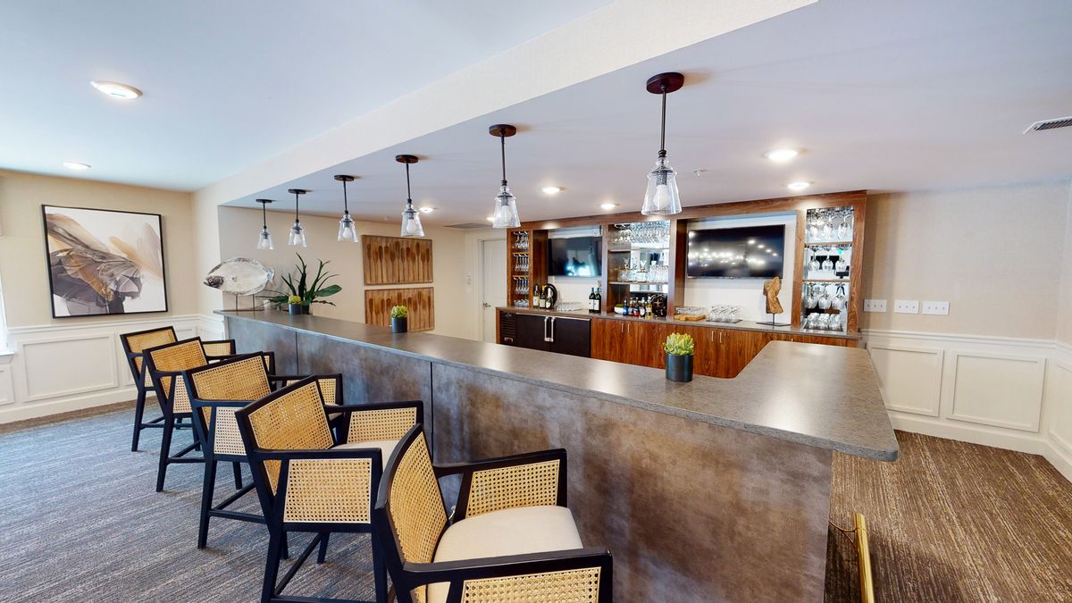 Modern bar interior with seating and stylish lighting.