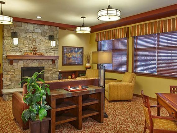 A cozy living room with a stone fireplace and comfortable seating arrangement.