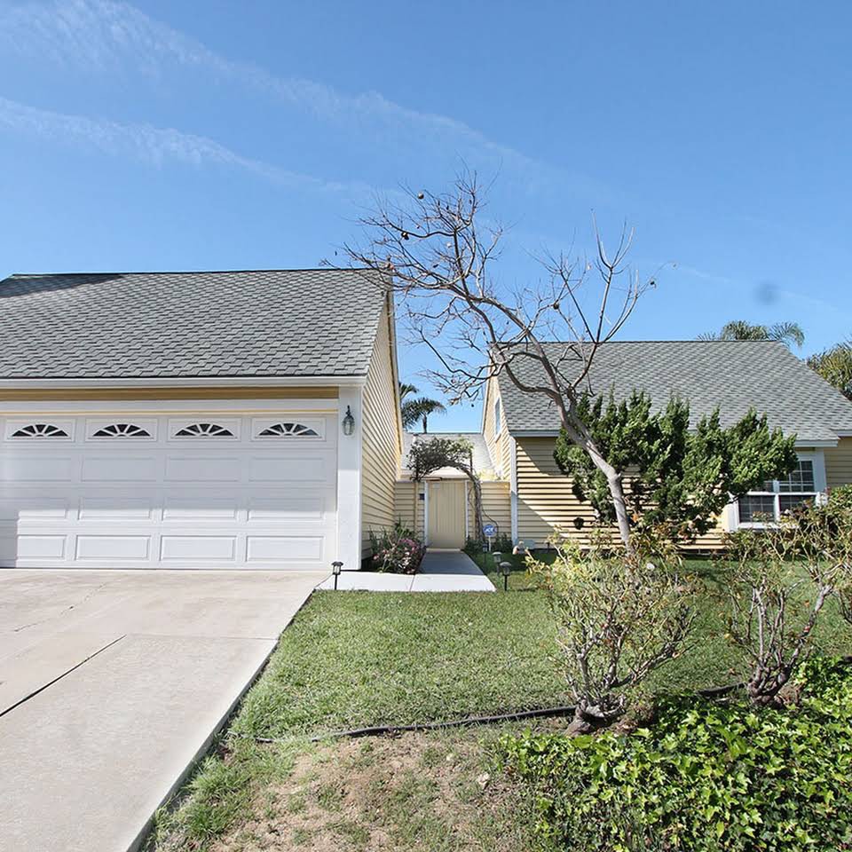 A suburban house with a two-car garage and a well-maintained front yard.