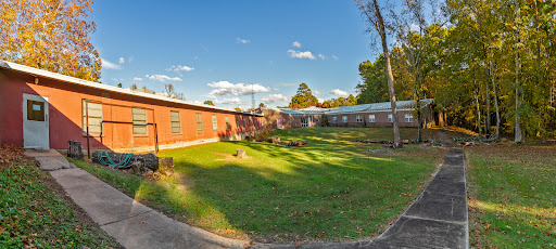 A scenic view of a building complex surrounded by lush green grass and a clear blue sky.