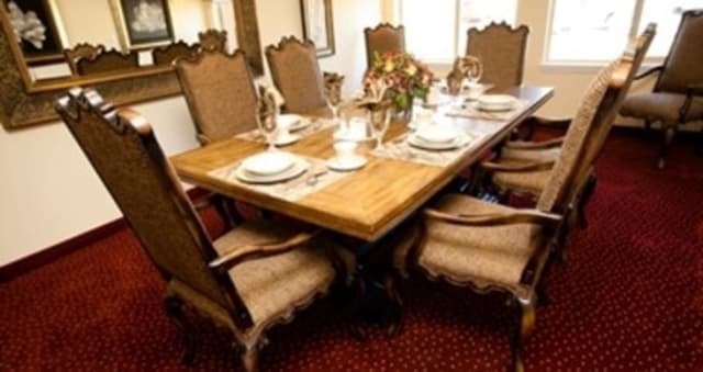 A beautifully set dining table with elegant chairs in a traditional dining room.