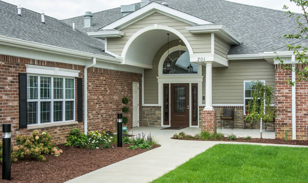 Front view of a modern house with brick exterior and landscaped walkway.