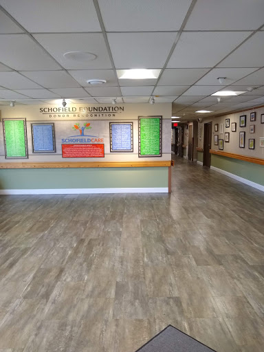 A spacious and modern lobby area featuring colorful wall displays and a reception desk.