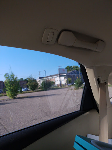 A view from inside a car, showcasing the blue sky and greenery outside.