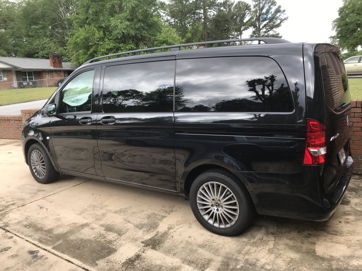 A black van parked on a driveway.