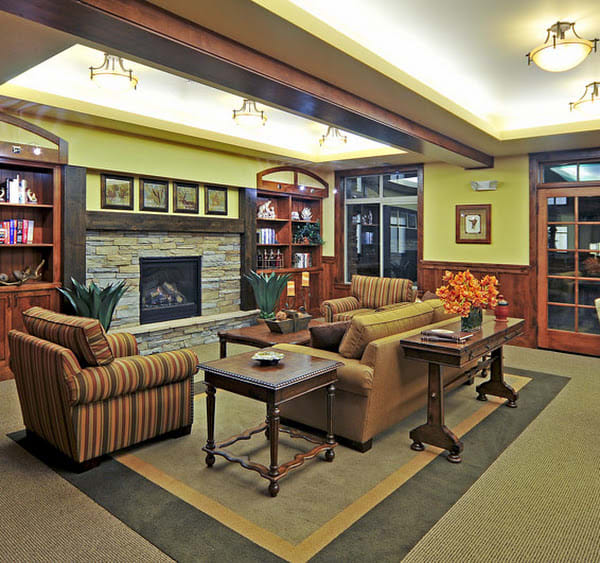 A cozy living room with comfortable seating, a fireplace, and bookshelves.