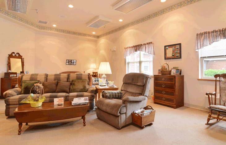 A cozy living room with a comfortable sofa, recliner, and warm lighting.