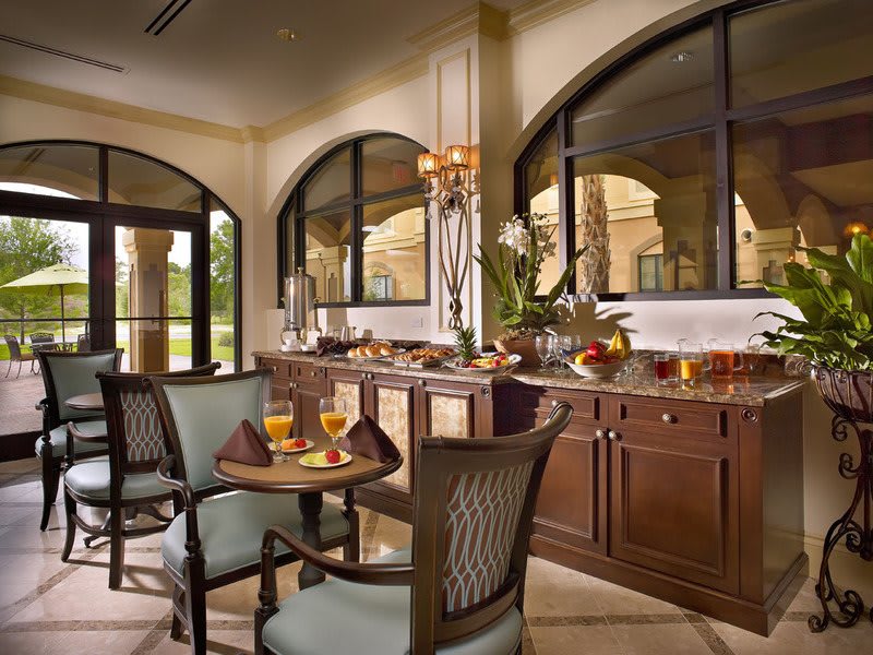 A luxurious breakfast buffet set up in an elegant dining area with large windows.