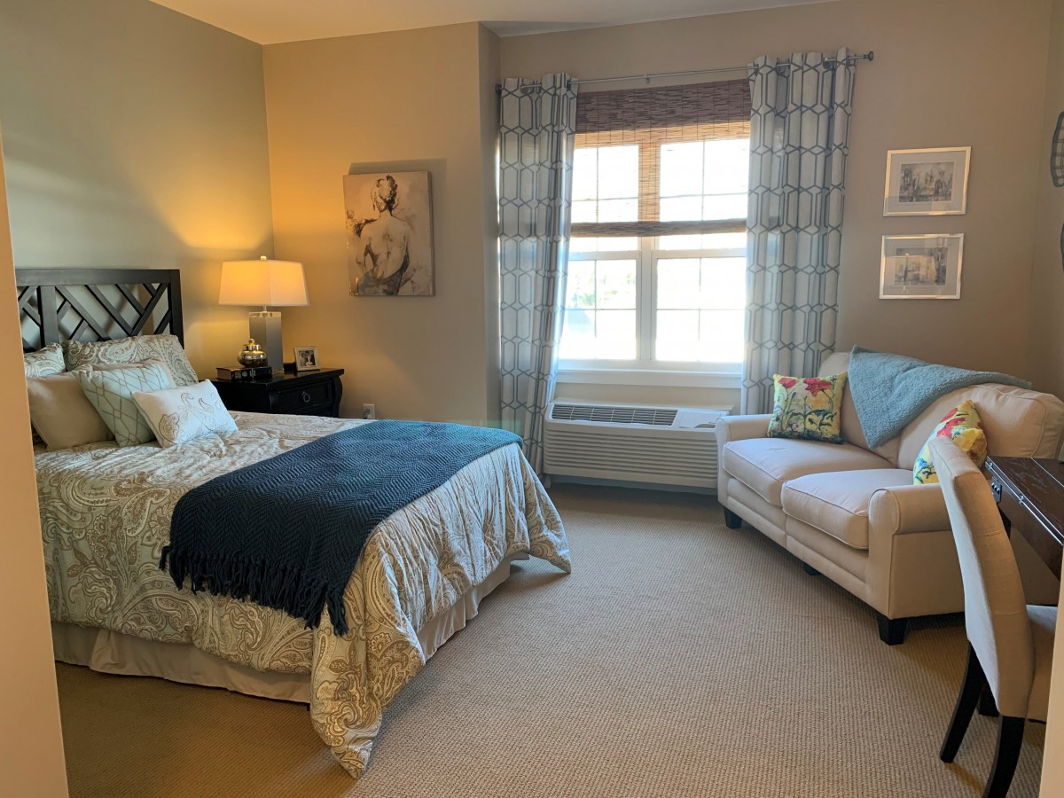 A cozy bedroom with a bed, a sofa, and decorative elements.