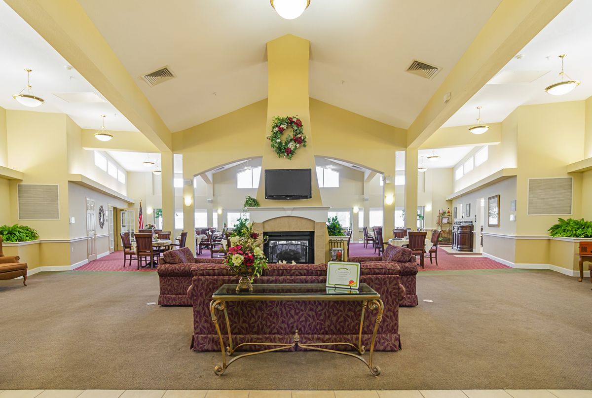 A spacious lobby with comfortable seating and a central fireplace.