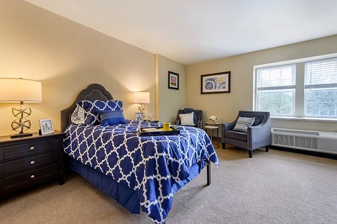 A cozy bedroom with a stylish bed and armchairs.