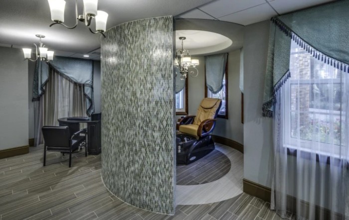 A modern spa interior featuring a massage chair in a relaxation area.